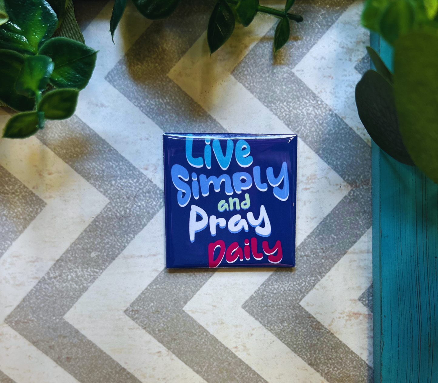 Scripture design drop refrigerator magnet with 'Live Simply and Pray Daily' text.